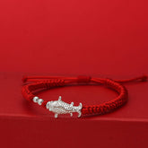 999 Silver Koi Fish Red String Bracelet – silver koi fish charm on handwoven red cord on red background, lucky jewelry