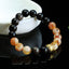 Obsidian Citrine Mantra Bracelet - Black and amber beads with gold mantra charm on dark reflective surface, crystal healing