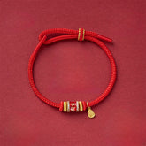 Fu Character Red String Bracelet – adjustable cord bracelet with crystal-embellished gold bead and teardrop charm, overhead view, red string bracelet