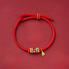 Fu Character Red String Bracelet – adjustable cord bracelet with crystal-embellished gold bead and teardrop charm, overhead view, red string bracelet