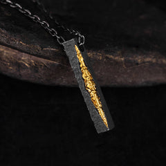 Om Mani Padme Hum Necklace – blackened silver pendant with gold vein inlay on dark oxidized chain, three-quarter angle, artisan necklace