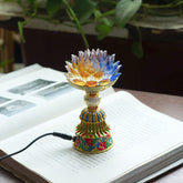 Lotus Liuli Glass Decor - clear crystal lotus flower lamp with blue amber petals and gold enamel base on open book, electric meditation light