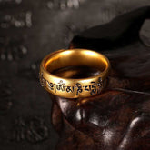 Om Mani Padme Hum Ring – Gold band with Tibetan engraving on carved wood stand, mantra ring