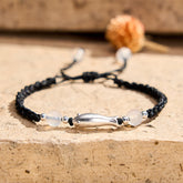 999 Sterling Silver Koi Fish Bracelet – silver koi charm with white agate on black braided rope, stone surface
