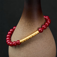 Cinnabar Om Mani Padme Hum Bracelet – Gold engraved tube on ceramic vase, red stone stretch bracelet