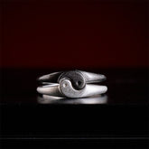 Yin Yang Copper Ring - Interlocking silver bands forming yin-yang symbol on black surface, couples rings