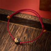 Ebony Yin Yang String Bracelet – red cord wooden charm on rustic wood, yin yang bracelet