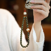 Sandalwood Cat Paw Charm – Green sandalwood bead phone strap with cat paw and kitty bodhi root charms, tea ceremony lifestyle scene