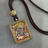 Tibetan Thangka Pendant – gold-framed blue deity amulet on brown cord, grey background, Buddhist protection jewelry