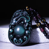 Tibetan Rainbow Obsidian PiXiu Necklace – close-up carved PiXiu with green iridescent sheen, black cord, feng shui wealth necklace