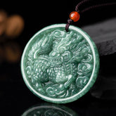 Jade Kirin Pendant – Green nephrite qilin relief carving with ruyi clouds and red carnelian bead on black, prosperity