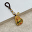 Gold filigree rotating calabash keychain with six-syllable mantra and jade gourd bead, brown cord