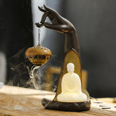 LED Buddha Hand Backflow Burner - dark hand holding censer with backflow smoke and glowing Buddha