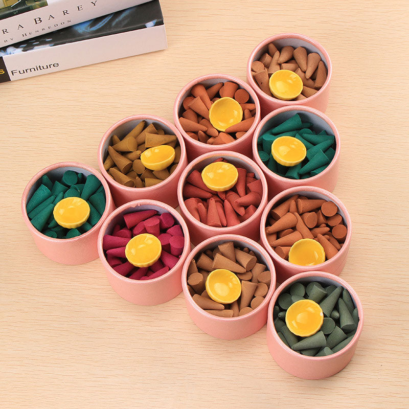 Tibetan incense cones – ten pink tubes of colorful meditation cones with yellow holders on wood, calming