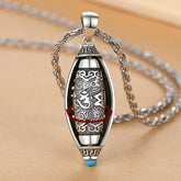 Tibetan Om Mani Padme Hum Pendant Necklace – rotating barrel with turquoise tip on warm surface, prayer wheel