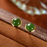 Hetian Cyan Jade Gold Plated Silver Stud Earrings on brown wood