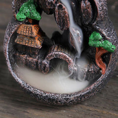 Resin Backflow Incense Burner – Stone sphere with arch tunnel, green trees and smoke pooling at base, meditation decor