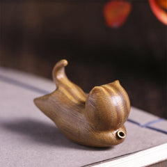 Green Sandalwood Cat Incense Burner - Rear view on book with warm ambient light, zen decor