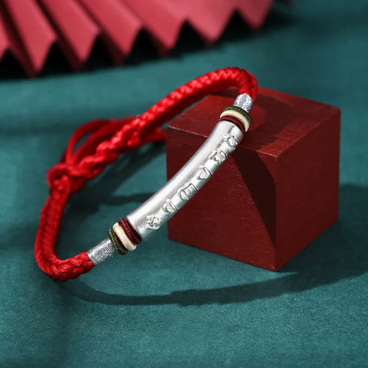 Om Mani Padme Hum Red String Bracelet – Red cord with silver mantra cylinder on wood display