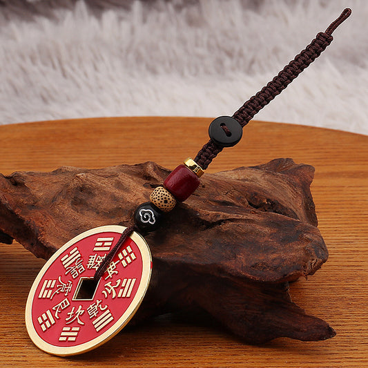 Shan Gui Keychain – red coin charm with gold border on brown cloud cord, driftwood display base
