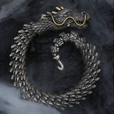 Nordic dragon copper alloy chain bracelet with sculpted dragon head turquoise eye gold horns and articulated scale body coiled on dark stone with atmospheric smoke