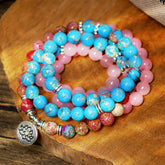 Tibetan Purple Miano Bead Lotus Mala - coiled strands with silver lotus charm on wood, meditation jewelry