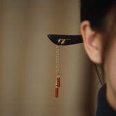 Side view of Red Agate & Ebony Wood Tassel Hairpin worn in hair, featuring gold bamboo leaf inlay and red agate cylinder tassels