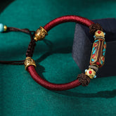 Tibetan Turquoise Om Mani Padme Hum Braided Bracelet – Burgundy cord with turquoise inlay barrel bead on emerald velvet