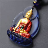 Liuli Crystal Medicine Buddha Pendant – closeup of blue liuli crystal with gold Buddha and red robe, macro detail