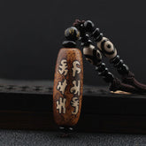 Dzi Bead Necklace – Mantra-engraved brown agate pendant with eye-pattern dzi beads on dark cord, spiritual