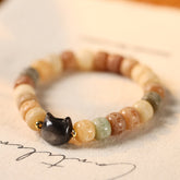 Bodhi Seed Cat Head Bracelet – Multi-color carved beads with black obsidian cat charm on fabric background, boho spiritual bracelet
