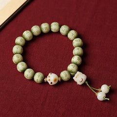 Bodhi Seed Bracelet – Top-down view of pale green beads with cat paw bead and dangling tassel, bodhi seed bracelet
