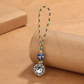 Yin Yang Bagua Keychain – Three-quarter view showing copper yin-yang medallion with blue mantra bead on braided cord, feng shui amulet