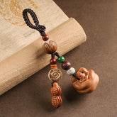 Peach wood Feng Shui keychain with peanut charm, lotus bodhi beads and carved persimmon pendant on vintage book