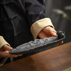 Hands presenting Pixiu incense burner with smoke, traditional robes, carved ruyi clouds, dark ceramic – Chinese incense holder