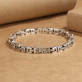 Dragon Om Mani Padme Hum Copper Bracelet - antiqued silver-tone copper link bracelet with central dragon motif and engraved Tibetan Om Mani Padme Hum mantra on rectangular links, flat lay on kraft paper