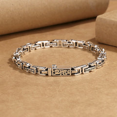 Dragon Om Mani Padme Hum Copper Bracelet - antiqued silver-tone copper link bracelet with central dragon motif and engraved Tibetan Om Mani Padme Hum mantra on rectangular links, flat lay on kraft paper