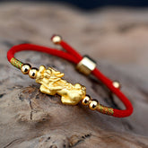 Gold-Plated PiXiu Red String Bracelet – gold PiXiu on adjustable red cord with gold beads, stone background