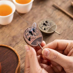 Copper Incense Burner Set – fan burner with chrysanthemum carving held in hand, tea cups nearby
