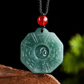 Natural Jade Bagua Yin Yang Pendant - Green jade necklace with bagua trigrams on wooden display, jade pendant