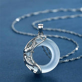 Sterling silver koi fish pendant necklace with white jade circle, yin-yang design on delicate twisted rope chain, blue background