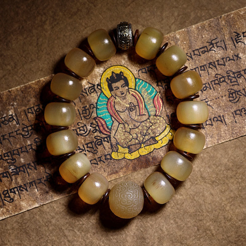 Tibetan Sheep Horn Skull Bracelet – Overhead view on Tibetan manuscript, amber beads with metal accents