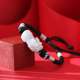 Natural Jade PiXiu Bracelet – side angle on red block, carved white jade detail, black cord, jade bracelet luck