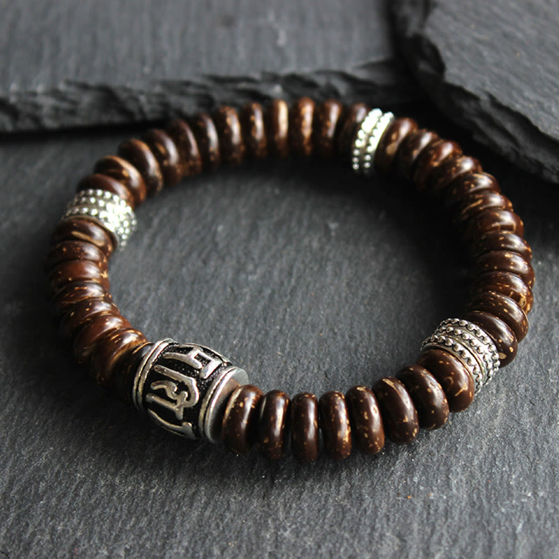 Om Mani Padme Hum Coconut Shell Bracelet – three-quarter view on dark stone, beaded bracelet
