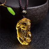 Citrine PiXiu Necklace Pendant – Yellow citrine PiXiu on dark cord with mantra bead near bowl, prosperity