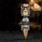 Tibetan Vajra Rotating Pendant – Gold Buddha seated in silver filigree frame with turquoise black inlaid sphere and engraved vajra blade, dark bokeh background frontal