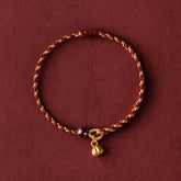 Red Gold Rope Lotus Braid Bracelet - circular flat lay with lotus pod charm, lucky cord bracelet