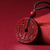 Cinnabar Pendant – deep red Shan Gui amulet coin with black cord on red fabric, protection charm