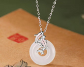 Koi Fish Peace Pendant – silver koi fish on white jade circle over beige fabric, zen harmony amulet