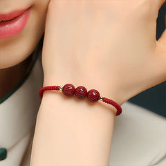Cinnabar Om Mani Padme Hum Braided Bracelet – Side view of carved beads on wrist, cinnabar jewelry